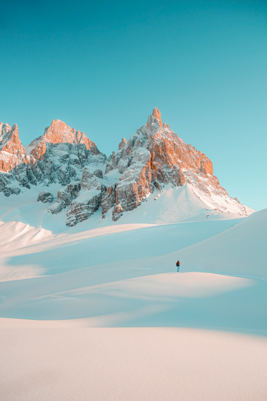 person walking on snow covered mountain during daytime
