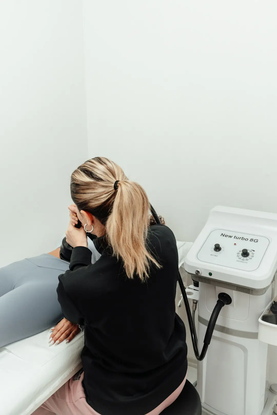 a woman sitting on top of a white couch next to a machine