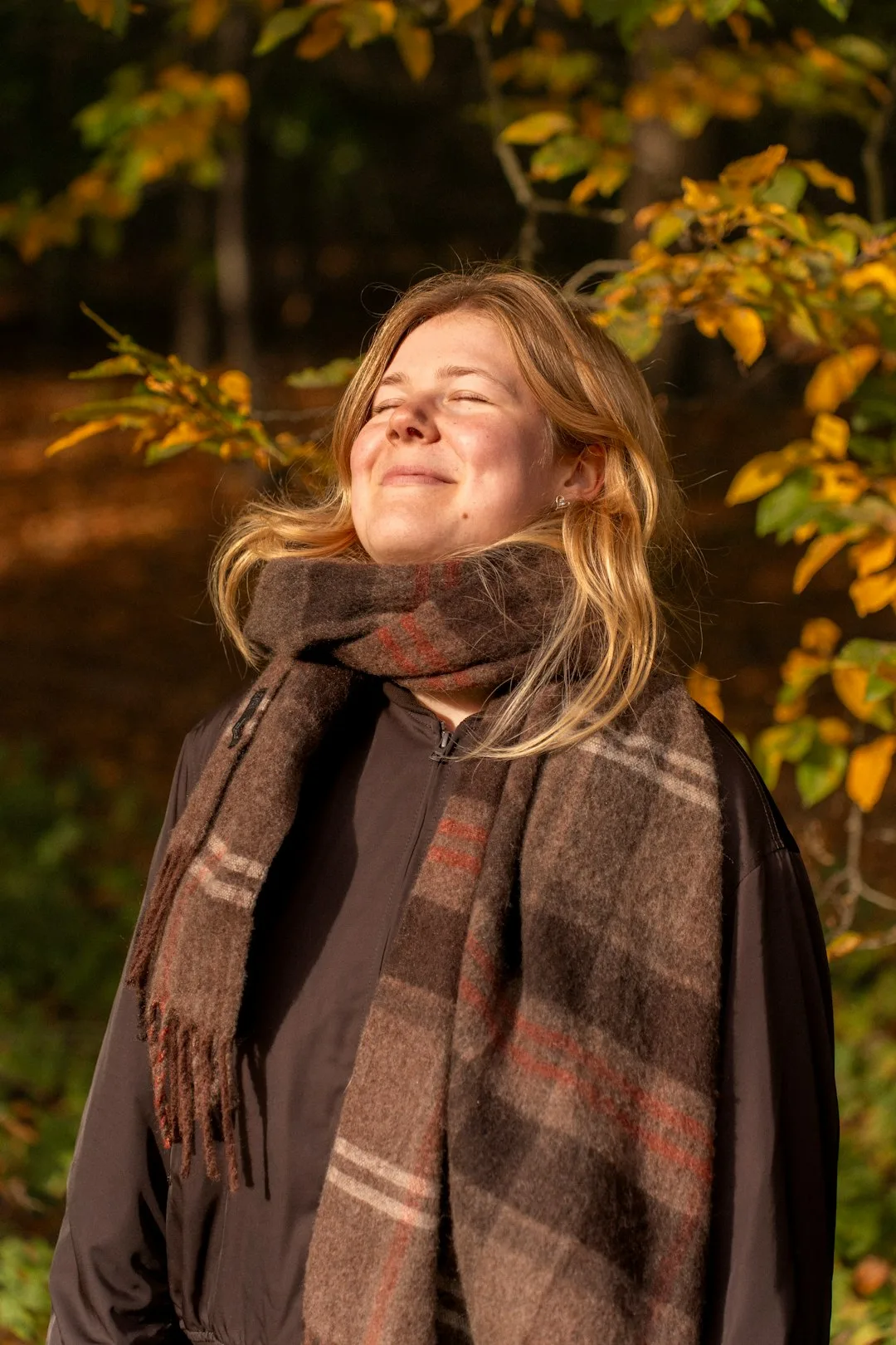 Photo by Sorin Basangeac Woman enjoying sunlight in autumn forest